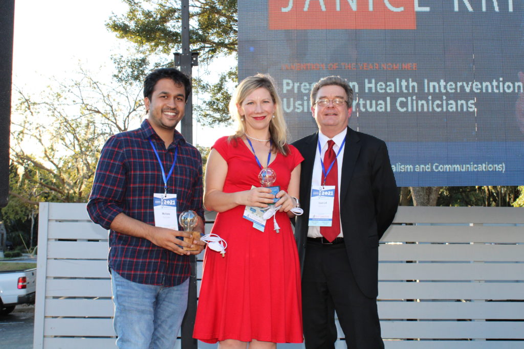 Mohan Zalake and Janice Krieger receive their lightbulb trophies from Dr. David Norton for invention of the year