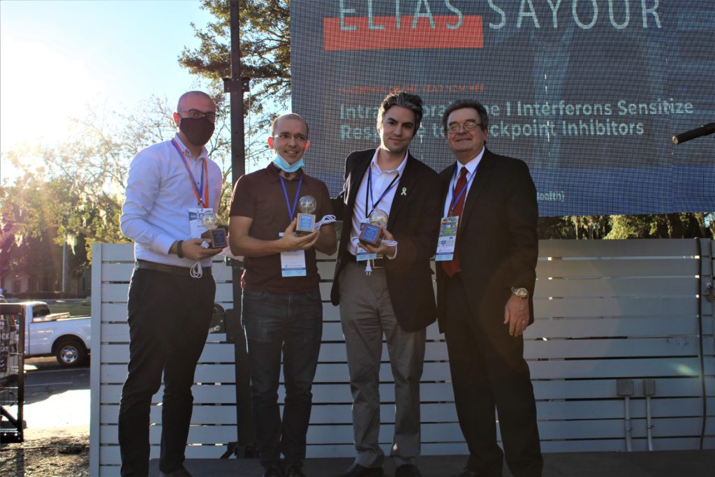 Three inventors -- Sadeem Qdaisat, Elias Sayour -- pose with their trophies and the vice president of UF Research, David Norton