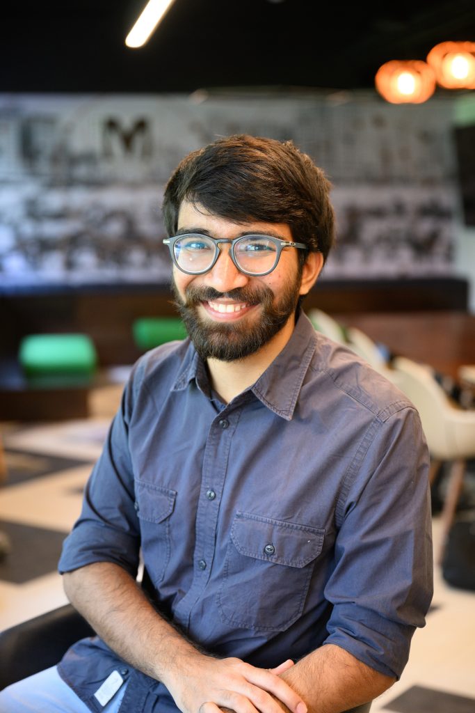 a man wearing glasses smiles for the camera