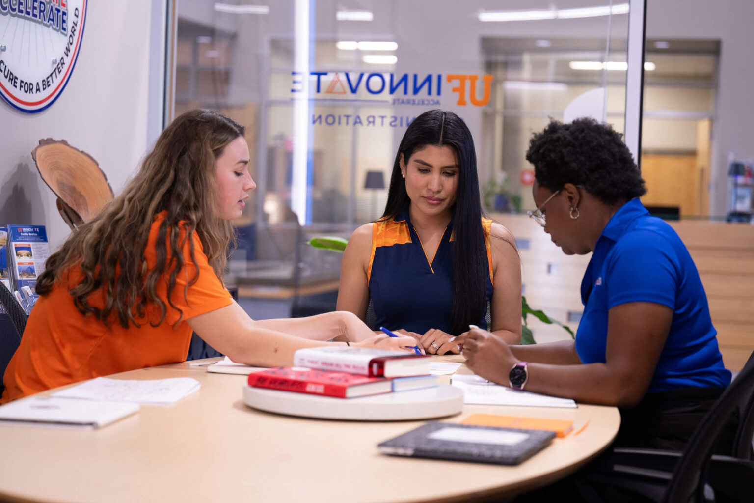 UF Innovate staff gathered around a desk, engaged in discussion.