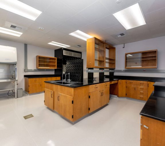 An empty lab with ample storage space and various pieces of experimental equipment.