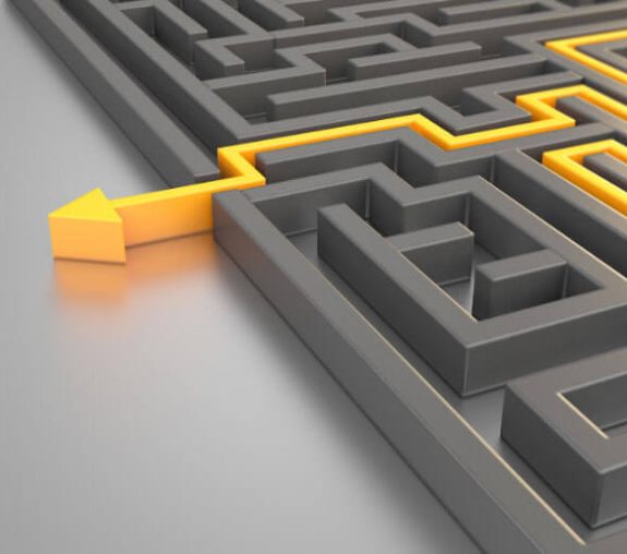 A gray maze with a yellow path leading through it, ending in a bold yellow arrow exiting the maze.