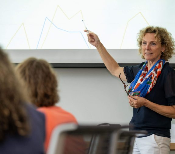 UF staff in a conference room, with one person giving a presentation using a screen.