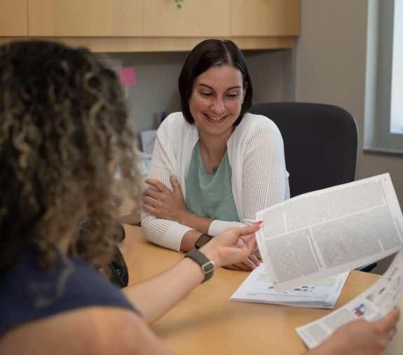 UF Innovate staff discussing something over a paper document in the office.