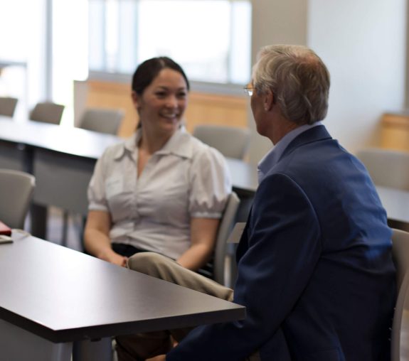 Two people having a conversation in a conference foom