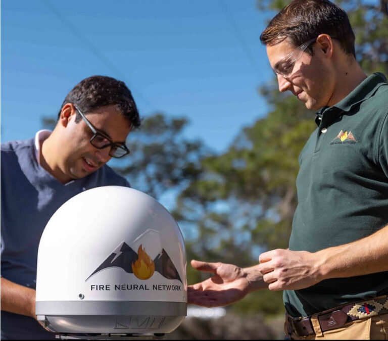 Two people examining a FNN(Fire Neural Network)'s device outdoors.