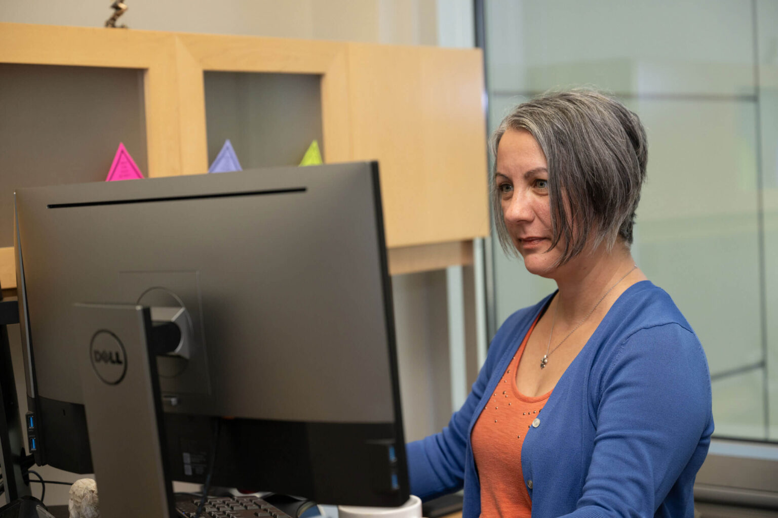 A UF Innovate staff member working on a computer in her office.
